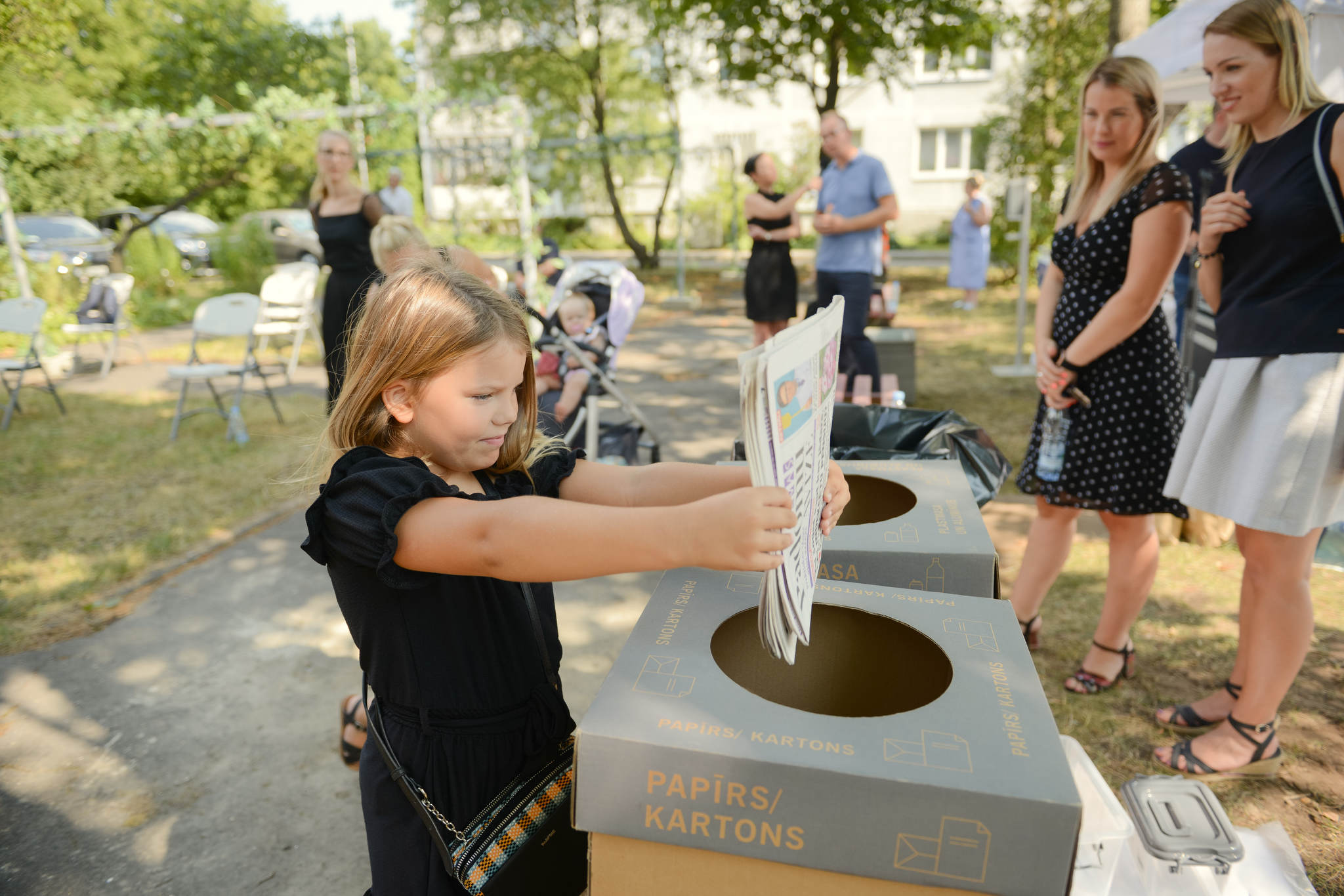Meitene izmet papīra atkritumu