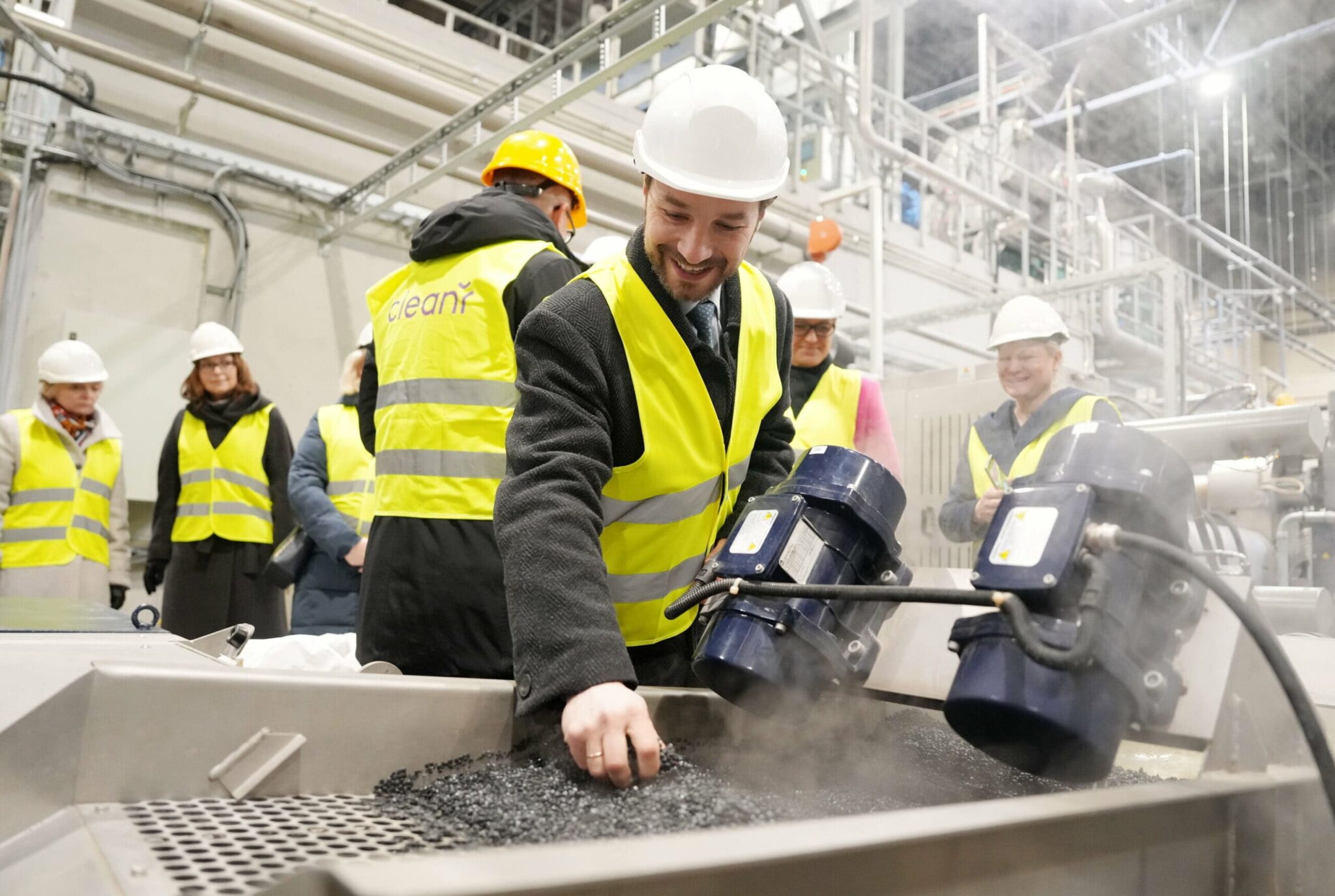 Vīrietis aplūko plastmasas granulas