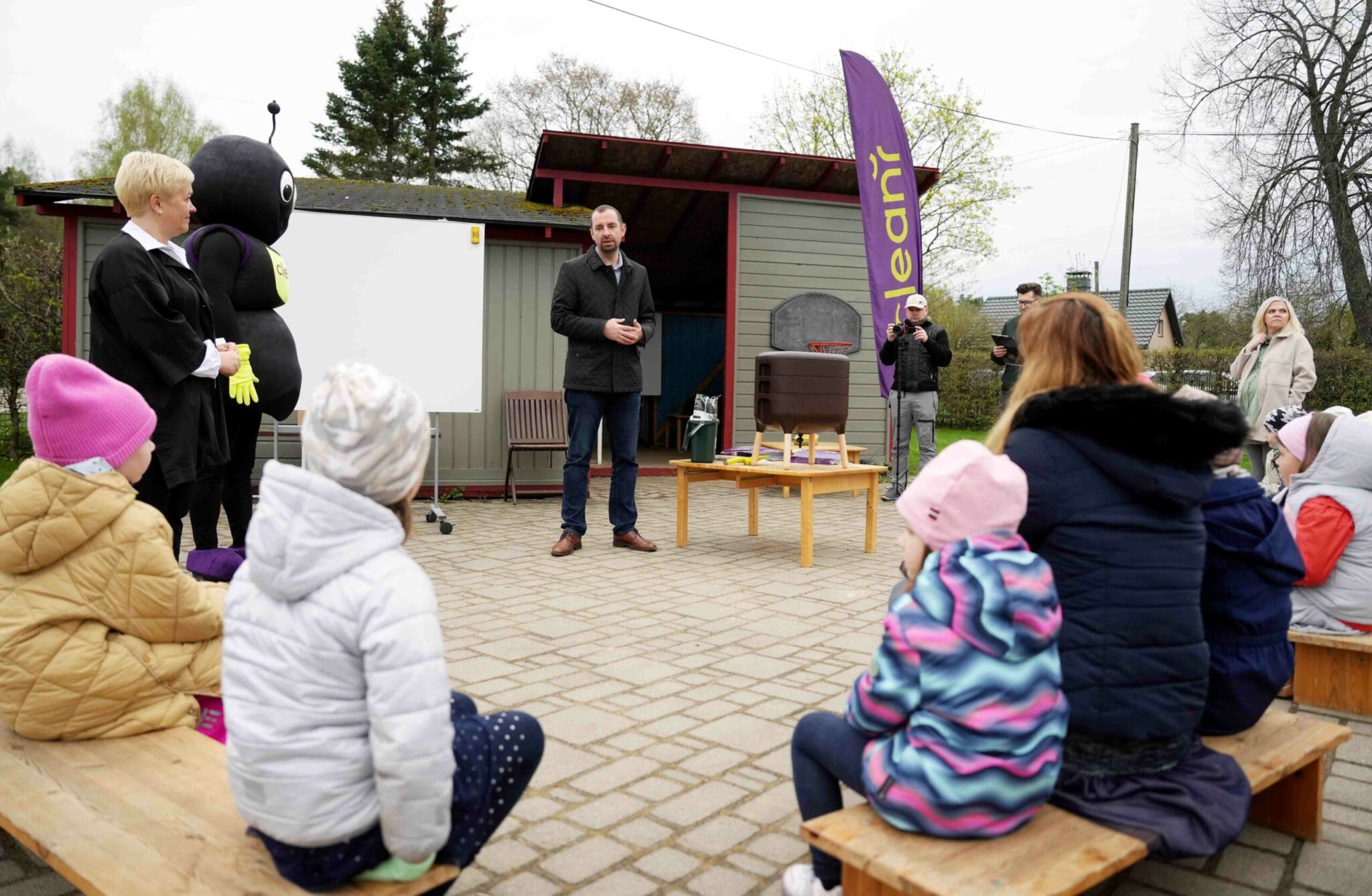 Vīrietis stāsta bērniem par atkritumu šķirošanu