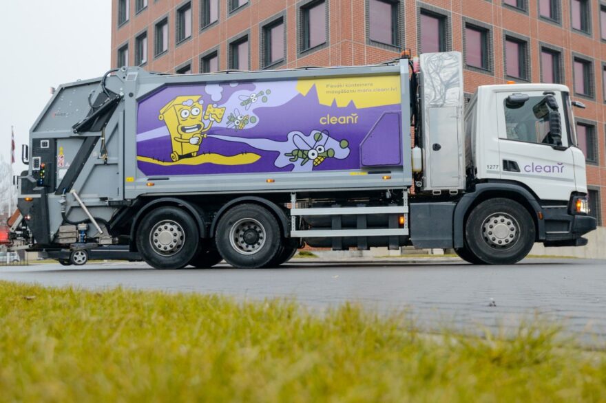 Atkritumu savākšanas automašīna ar ilustrāciju uz sāna