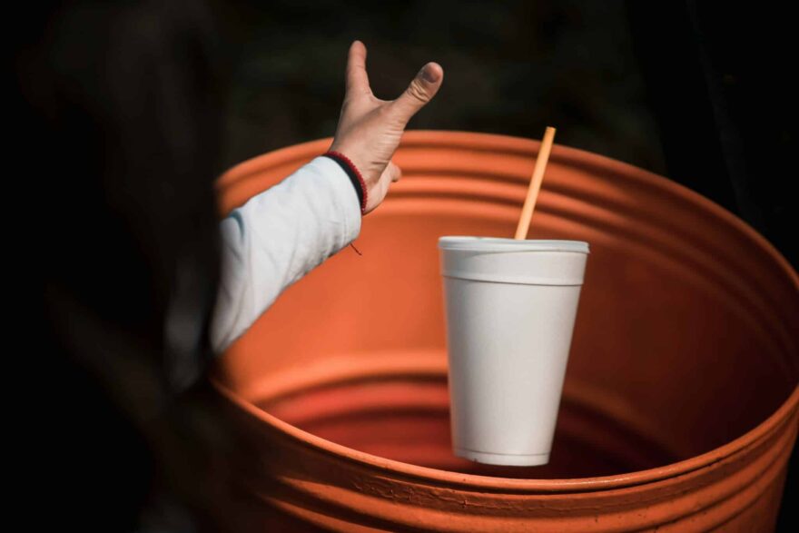 Cilvēks izmet plastmasas glāzi